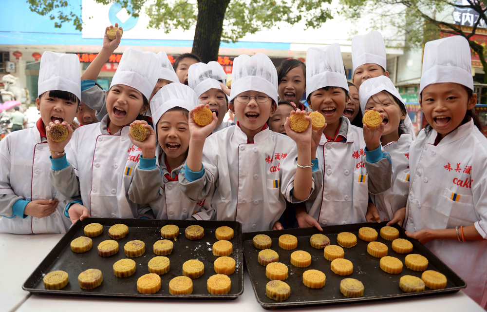 江西省广昌县的60多名留守儿童到蛋糕店学习制作月饼  新华社