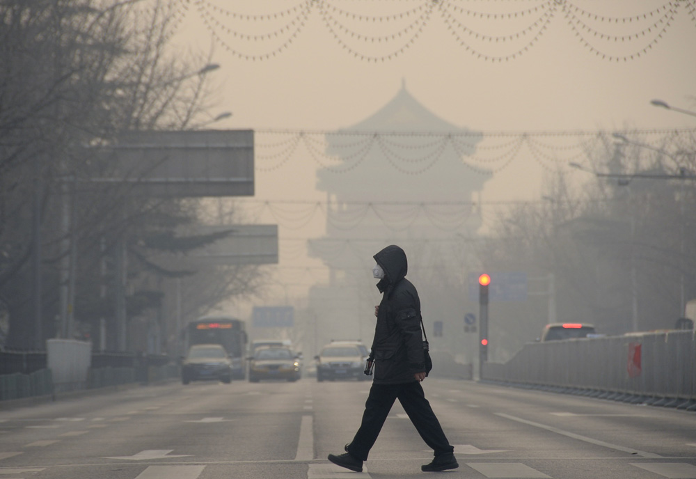 图:行人走在雾霾笼罩的北京街头  资料图片