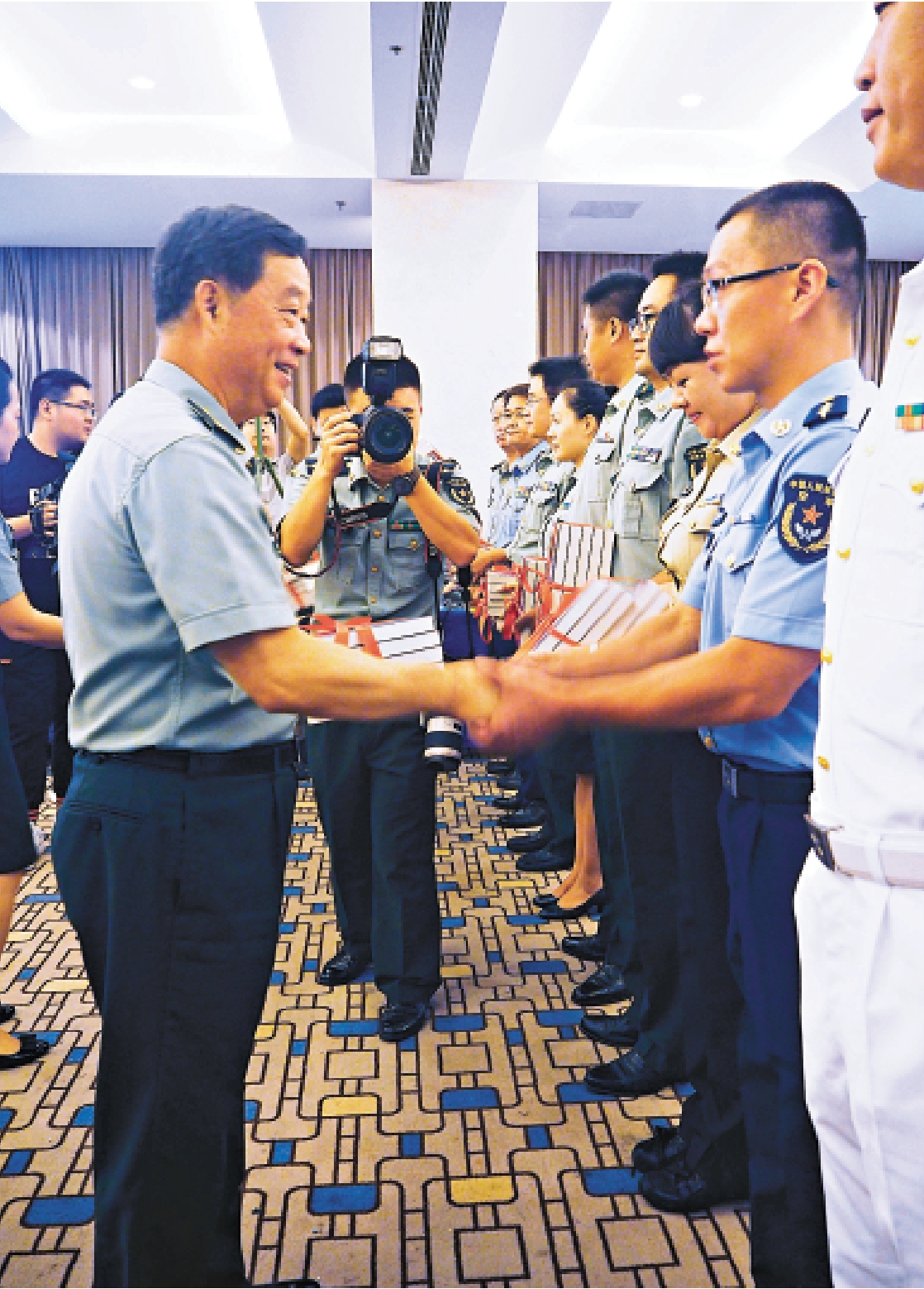 图:国防大学校长张仕波上将向部队官兵代表和国防大学学员代表赠送