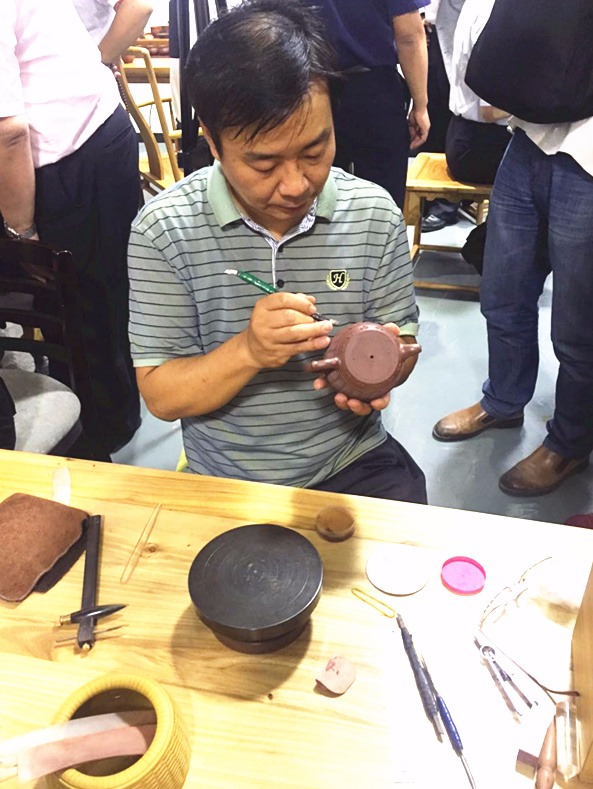 残疾紫砂艺人庄其军在现场展示紫砂技艺
