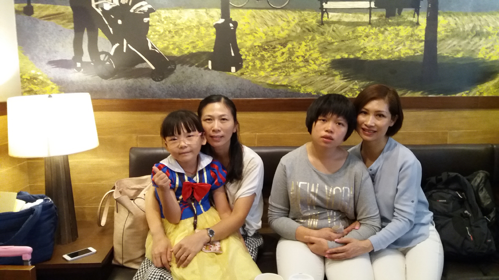 家属阮佩玲(左二)和袁碧霞(右一)积极面对罕见病 大公报记者黄颖雅摄