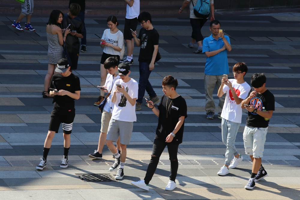 图:行人一边走路,一边看手机 ,已成街头的风景\资料图片