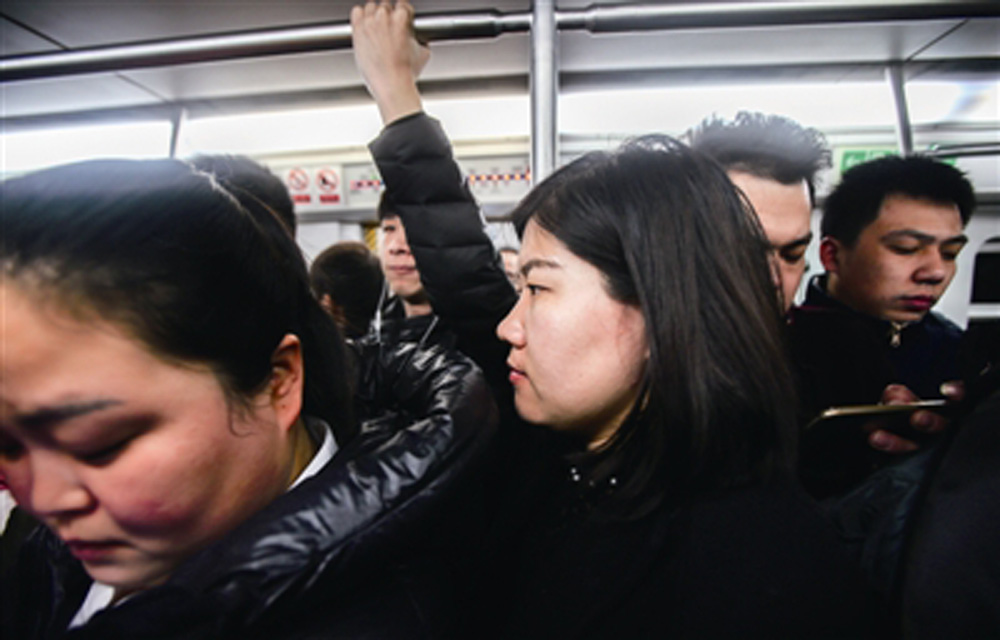 图:姜京子(图中)乘地铁,时值上班早高峰,车厢拥挤/网络图片