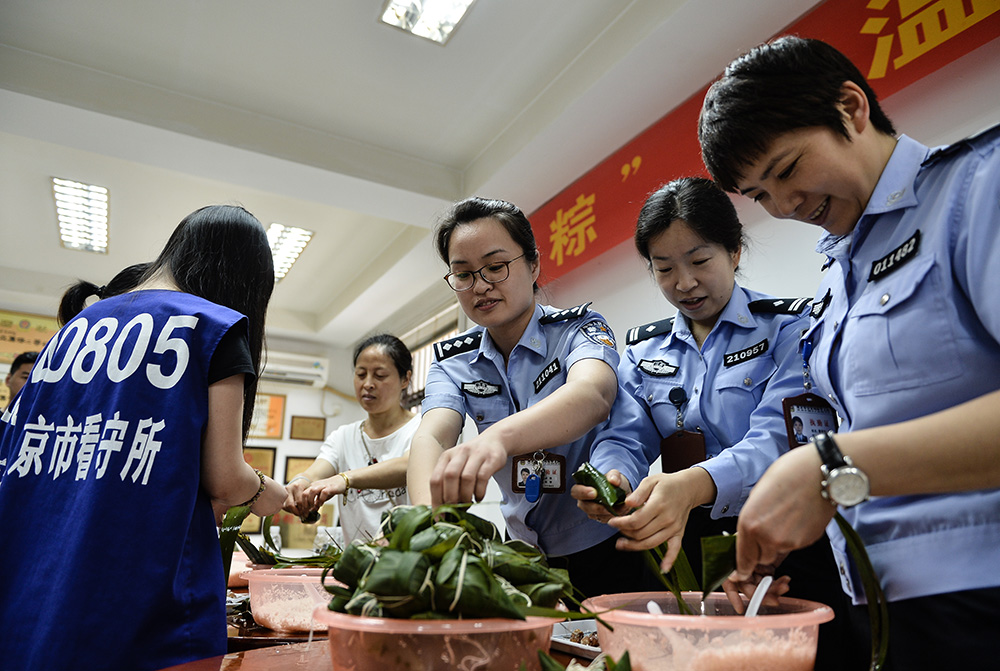 图:民警在南京市看守所与在押人员及其家属在一起包糭子  资料图片