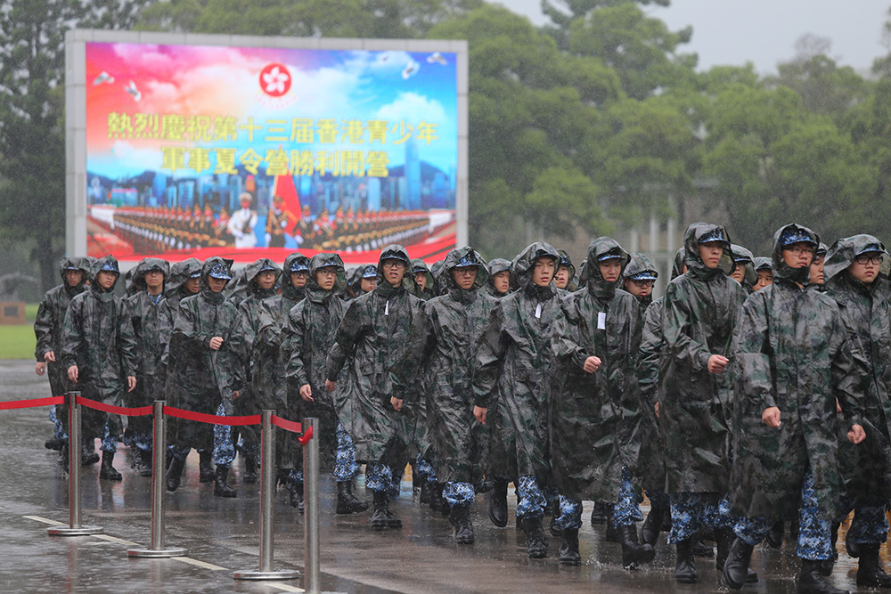 图:仪式中途,骤来一阵暴雨,五百名"小兵"队伍迅速换上雨衣,列队听取