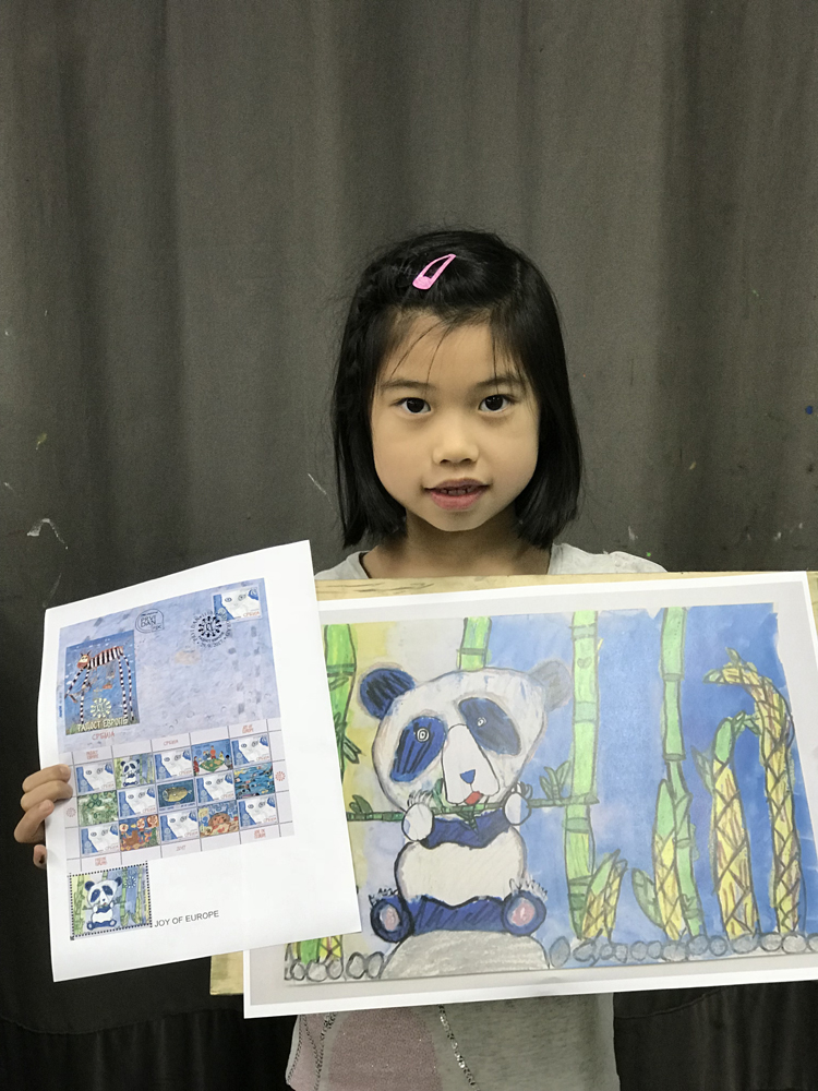 图:许嘉澄凭作品小熊猫开饭了,获选登上当地邮票小版张 六岁港生画出国际!就读小学一年级的许嘉澄,凭作品小熊猫开饭了,在塞尔维亚首都贝尔格莱德儿童艺术节的绘画创作比赛,从23个国家及地区、四千多份作品中脱颖而出,获选登上当地邮票小版张的八幅绘画作品之一,成为首位作品获选印製成当地邮票的港生。 嘉澄叻叻,郑晴当然要访问许妈妈,有何教女心得。许妈妈说,嘉澄自小热爱画画,当看见喜爱的事物,便主动拿起画笔画下来。嘉澄四岁起到画室学习绘画,今次是首次参加大型绘画比赛,对画作获印製成邮票,感